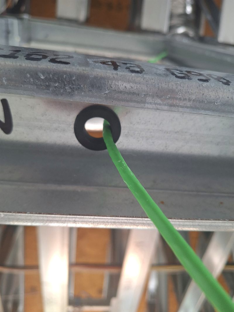 Cat6 cable run through a grommet in a steel stud during a pre-wire
