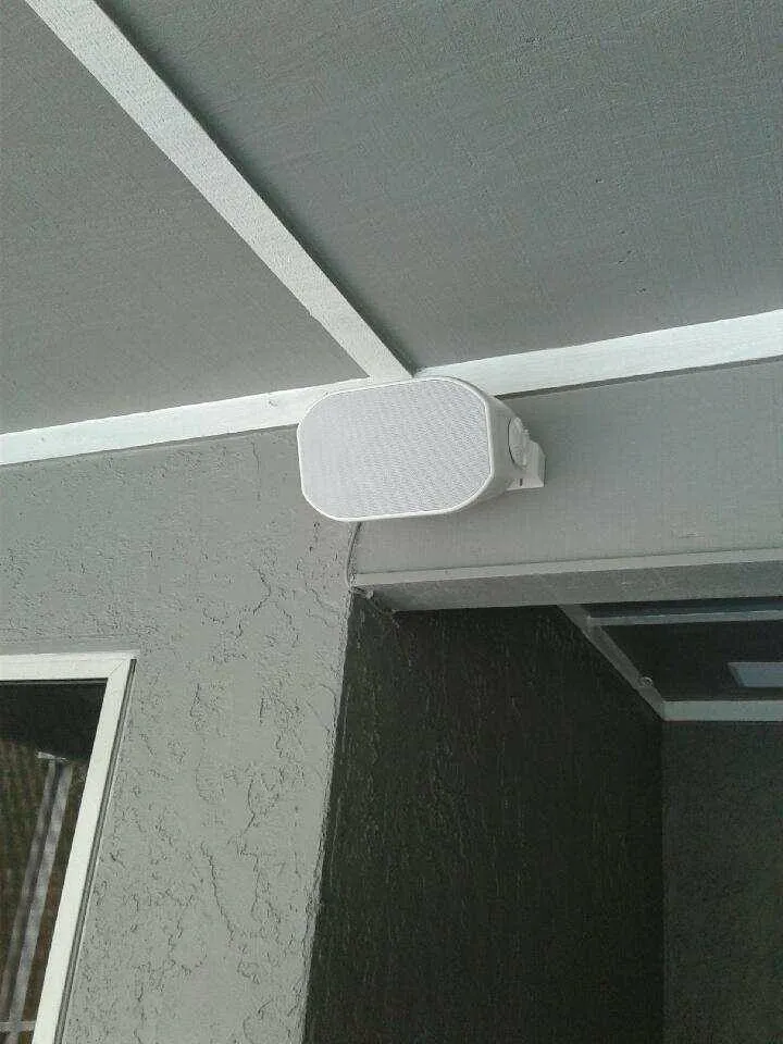Outdoor speaker mounted under a roof eave