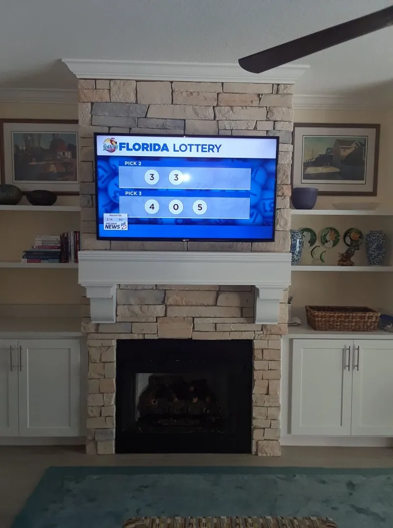 TV above a white fireplace with a stone surround