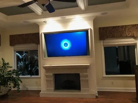 TV set into a lit recess above a fireplace