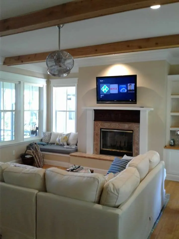 TV over a fireplace in a bright living room