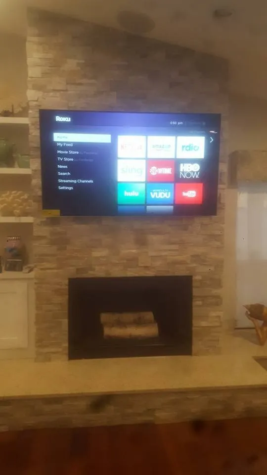 TV mounted above a stone fireplace