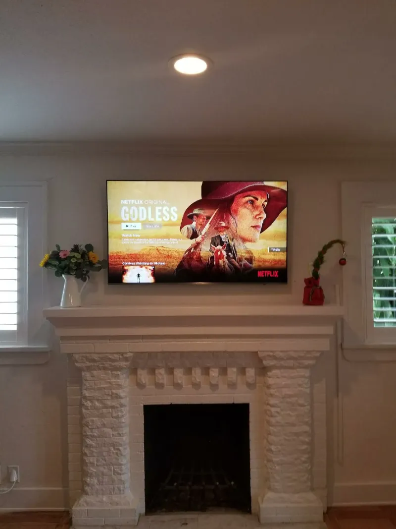 TV above a white fireplace mantel