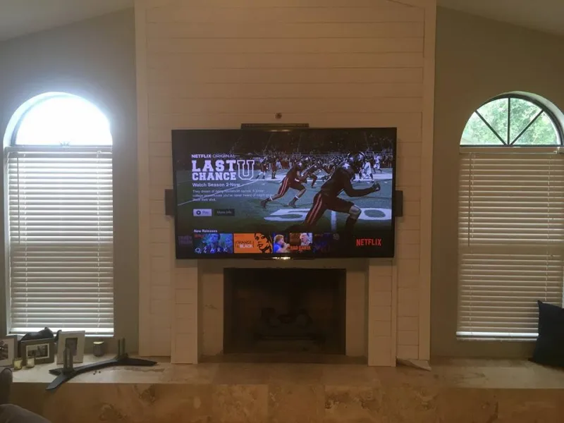 TV over a fireplace between arched windows