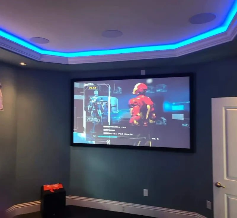 Home theater with a projection screen and blue LED cove lighting