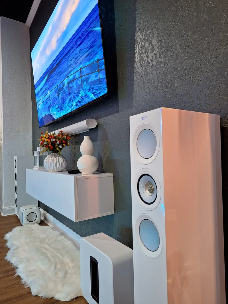 TV and white floor-standing speakers