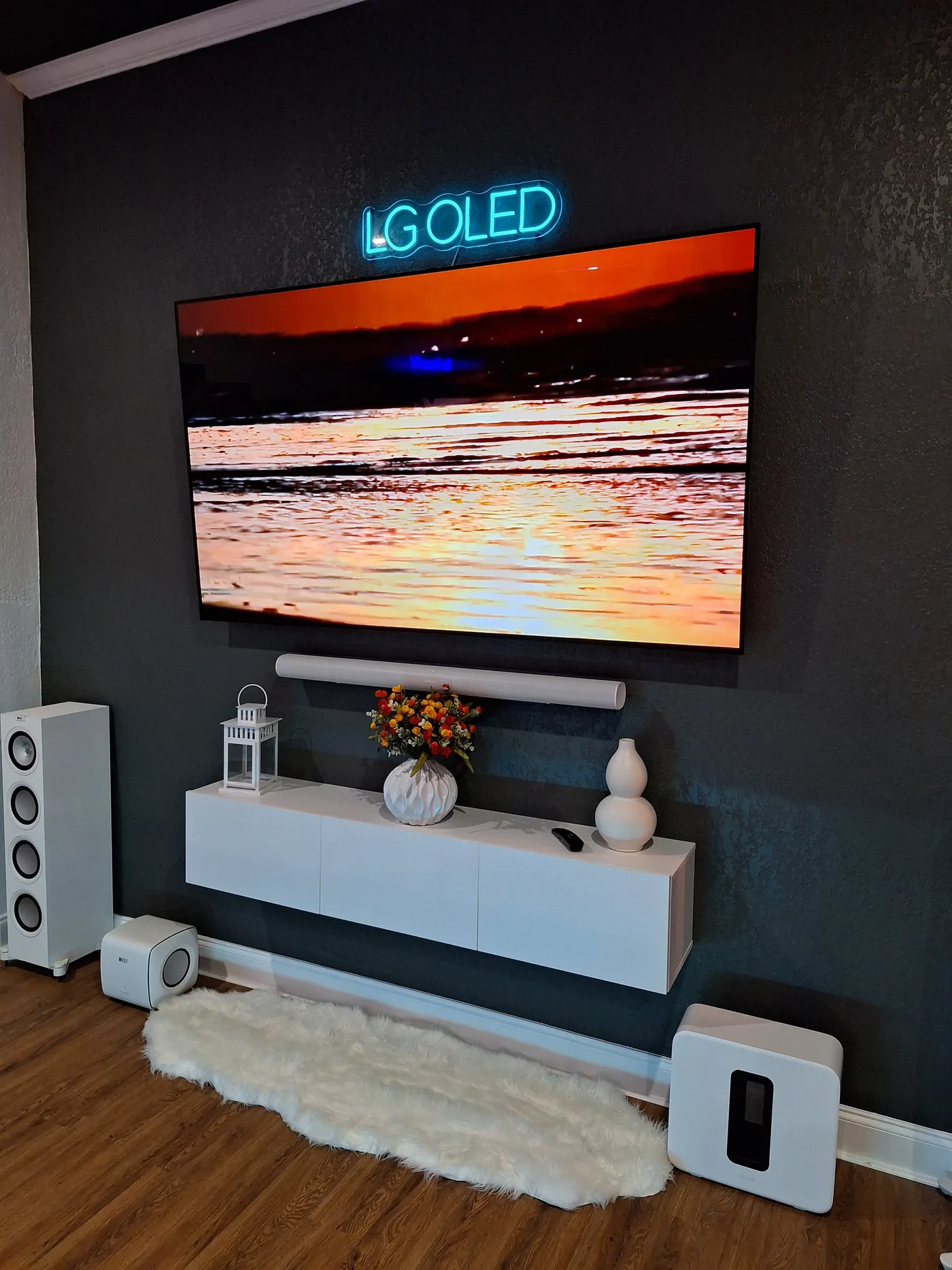 Large TV with a soundbar and white speakers