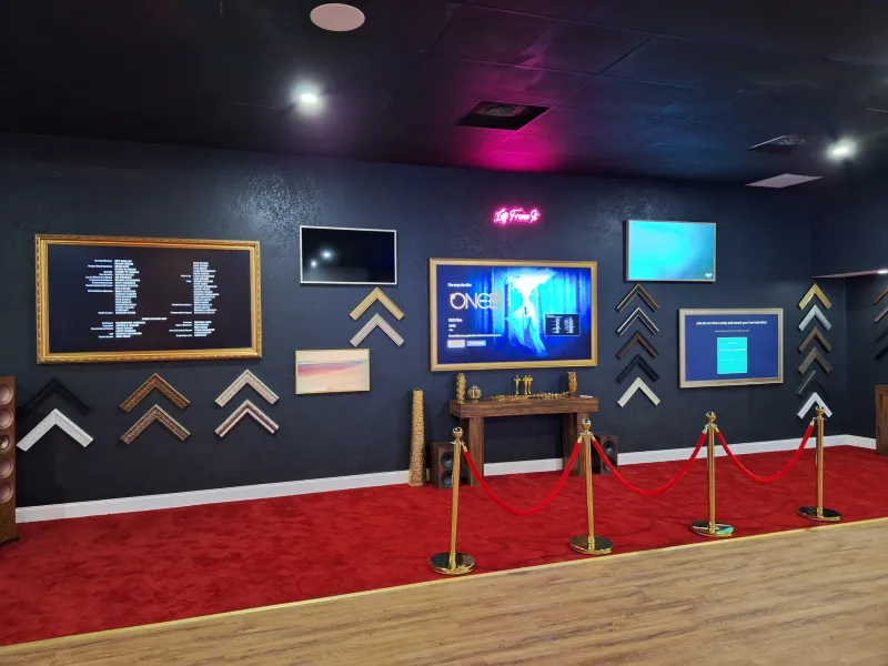The showroom floor with framed TVs and a red carpet