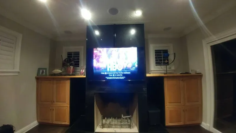 TV set into a dark built-in wall with lighting