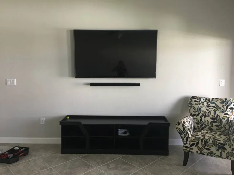 TV and soundbar above a black media console